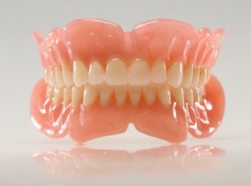 A set of dentures in front of a white background.