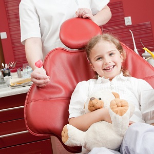 Little girl smiling in a dental chair.