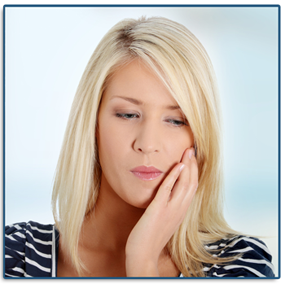 A woman grabbing her jaw in need of an emergency dentist. 