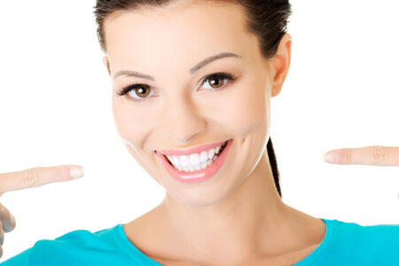 Woman pointing at her white teeth